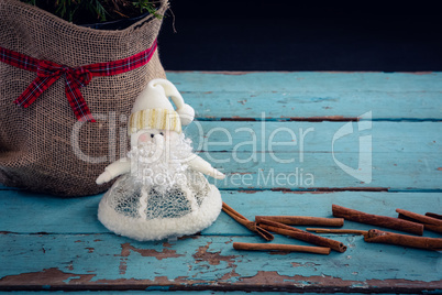 Sack, cinnamon stick and christmas decoration of wooden plank
