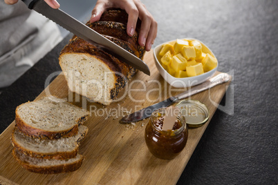 Woman cutting freshly baked multigrain bread
