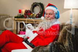 Santa claus using digital tablet at home during christmas time