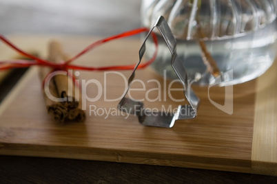 Wrapped cinnamons and cookie cutter on chopping board