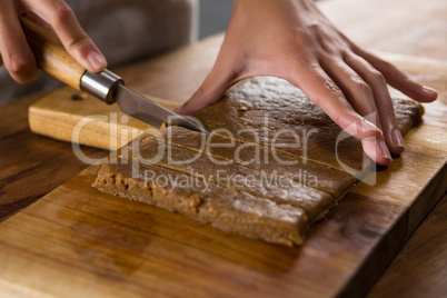 Woman slicing dough on chopping board