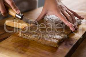 Woman slicing dough on chopping board