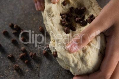 Woman kneading dough with chocolate chips
