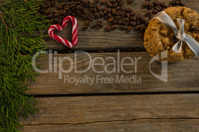 High angle view of cookies with candy cane and coffee beans by twigs