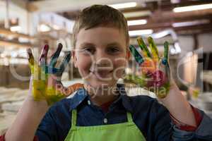 Boy showing colorful paint on his hands