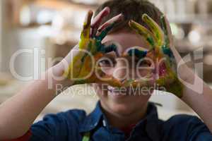 Boy gesturing with painted hands