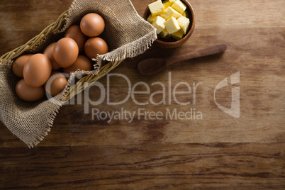 Brown eggs and cheese cubes on a wooden table