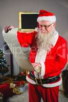 Santa Claus reading scroll in living room