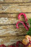Sweet food and christmas decorations on wooden plank