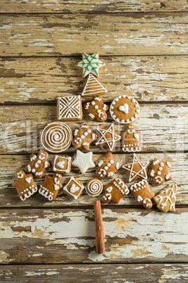 Gingerbread cookies arranged in christmas tree shape on wooden plank