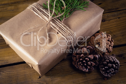 Gift box, fir and pine cone on wooden table