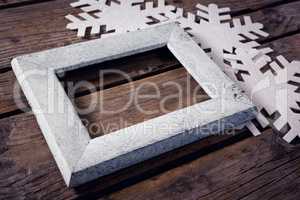 Handmade frame and snowflake on wooden plank