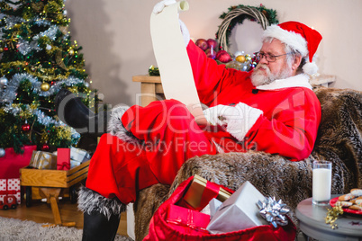 Santa Claus reading scroll in living room