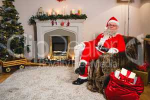 Portrait of santa claus sitting on sofa in living room at home