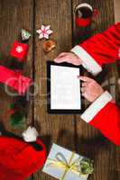 Santa Claus using digital tablet on table