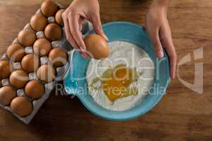 Man breaking eggs in the flour in bowl