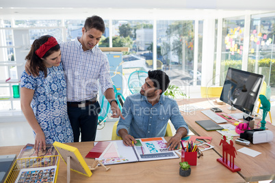 Team of graphic designers discussing over document