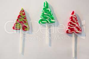 Christmas tree lollipops on white background