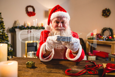 Portrait of santa claus showing gift box in living room at home