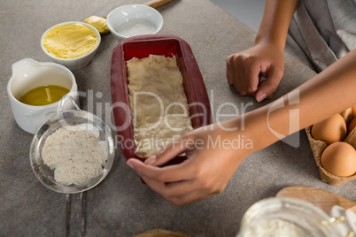 Woman preparing dough surrounded with various ingredients