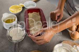 Woman preparing dough surrounded with various ingredients