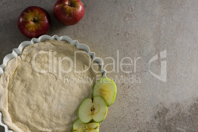 Raw tart with slice apple on table