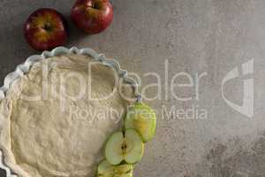 Raw tart with slice apple on table