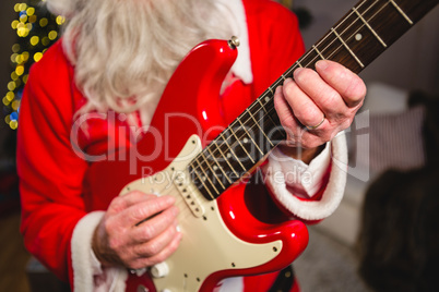 Mid-section of santa claus playing a guitar