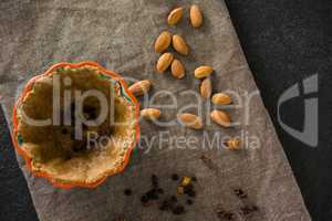 Raisin being stuffed in tart with almond on wax paper