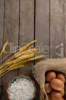 Wheat stem, eggs and flour kept on a table