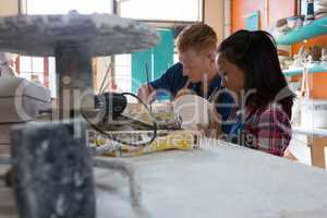 Male potter and girl painting bowl