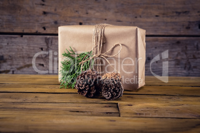 Gift box, fir and pine cone on wooden table