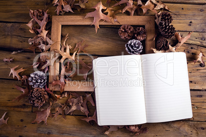 Open book and frame on wooden table