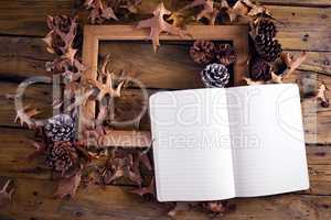 Open book and frame on wooden table