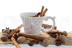Spice tea with various ingredients against white background