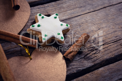 Cinnamon sticks, cookies and christmas decoration on wooden plank