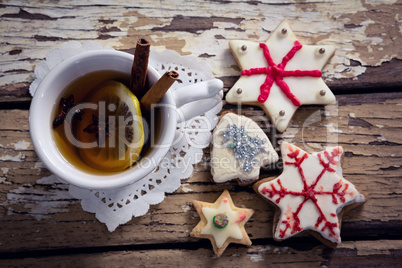 Tea, spices and cookies on wooden plank