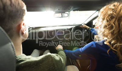 Woman driving while sitting with man in car