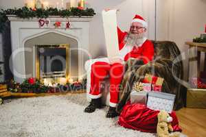 Santa Claus reading scroll in living room