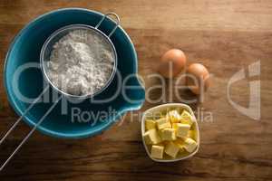 Flour in stainer with eggs and cheese