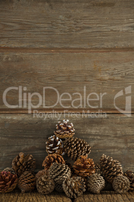 Pine cones against wooden plank