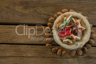 Overhead view of star shape cookies in bowl amidst walnuts