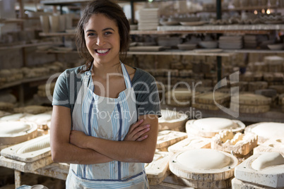 Confident female potter standing with arms crossed