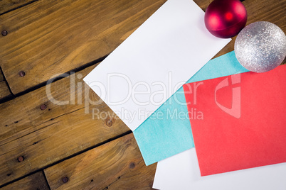 Envelopes and christmas baubles on wooden table