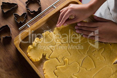 Man removing gingerbread dough on wooden table
