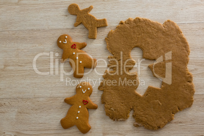 Gingerbreads and dough on wooden table