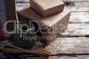 Gift boxes with wrapping material on wooden plank