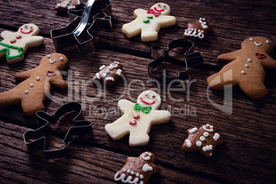 Cookie cutter and gingerbread cookies on wooden plank