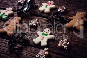 Cookie cutter and gingerbread cookies on wooden plank