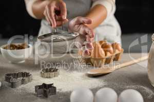 Woman staining flour in sieve